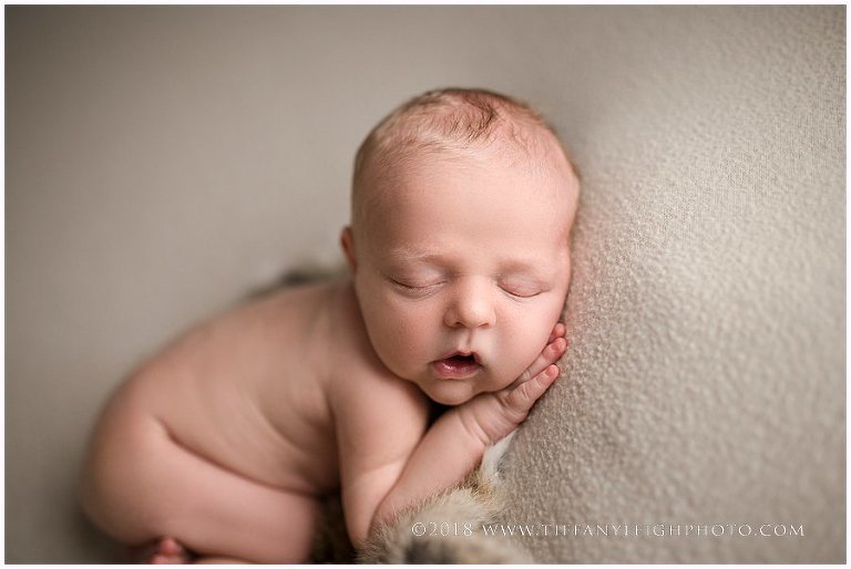 A baby sleeps with his mouth open. 