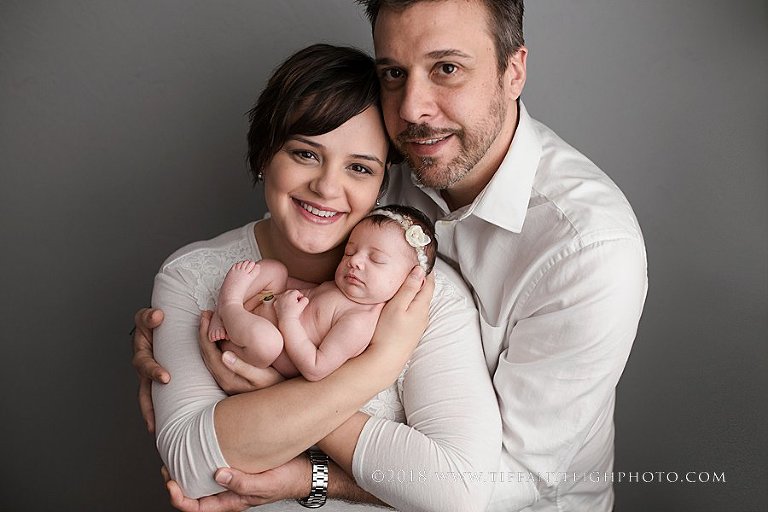 A family poses for photos captured by a Newborn Photographer In Gainsville. 