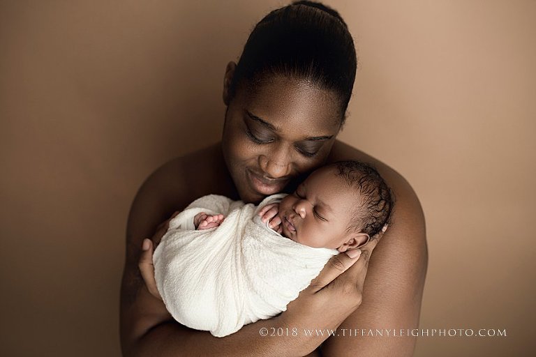 Gainsville Newborn Photography | A parent holds his new baby. 