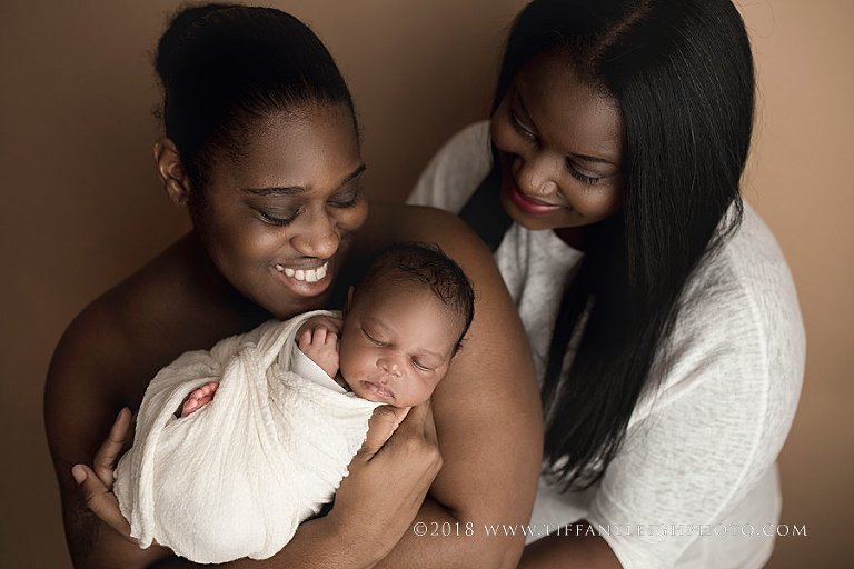 Two parents look at their new baby. 