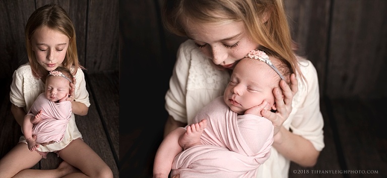 A little girl holds her new sister