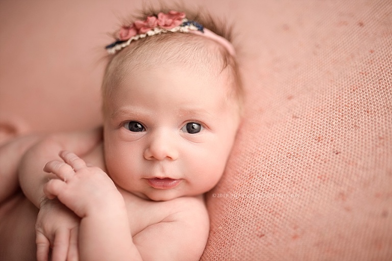 A newborn opens her eyes. 