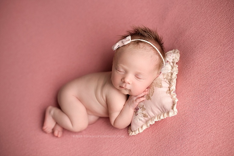 A baby sleeps with a little pillow under her head