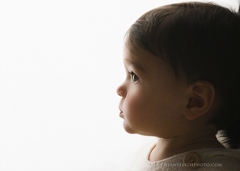 A baby's cheeks glow when the light touches them. 