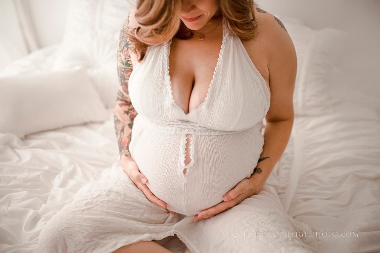 pregnant mom looking at newborn