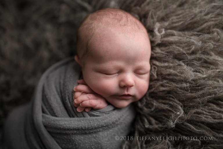 baby boy wrapped on rug