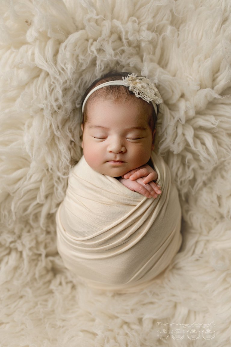 baby girl swaddled on rug