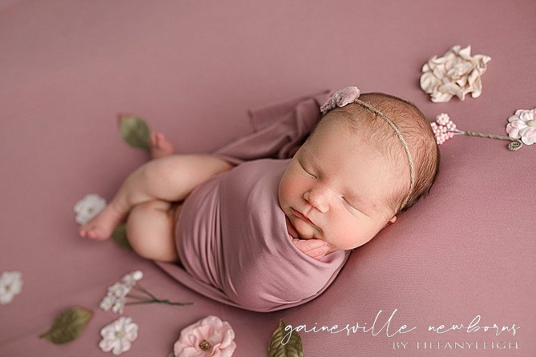 newborn baby girl wrapped flowers