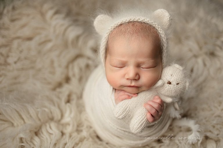 Newborn holding teddy bear