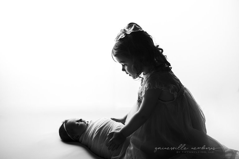 black and white baby sibling photo