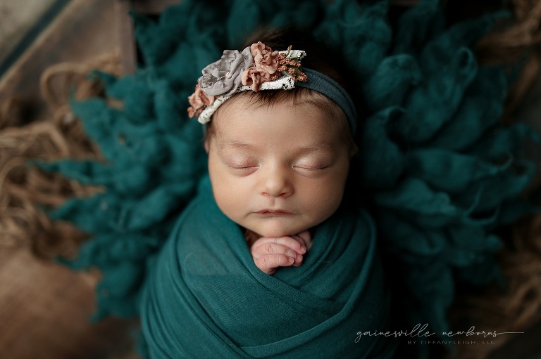 newborn girl wrapped in emerald