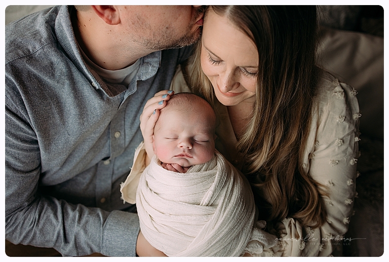 parents lovingly holding baby