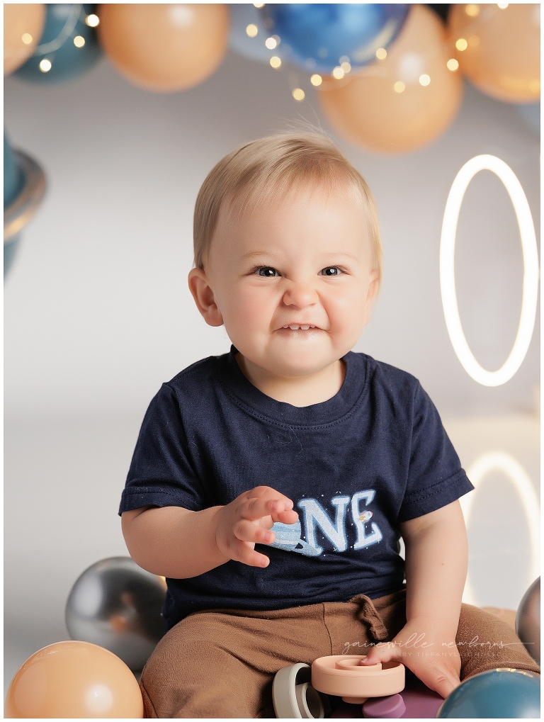 top gun,gainesville,florida,ocala,lake city,first birthday,one year old,cake smash,custom cake smash set,balloon garland,party,almost one,newborn to birthday,growing up,professional photography studio,premier cake smash photographer,celebrate,uf shands,hca north florida,first birthday cake,cake topper,theme,messy,icing,