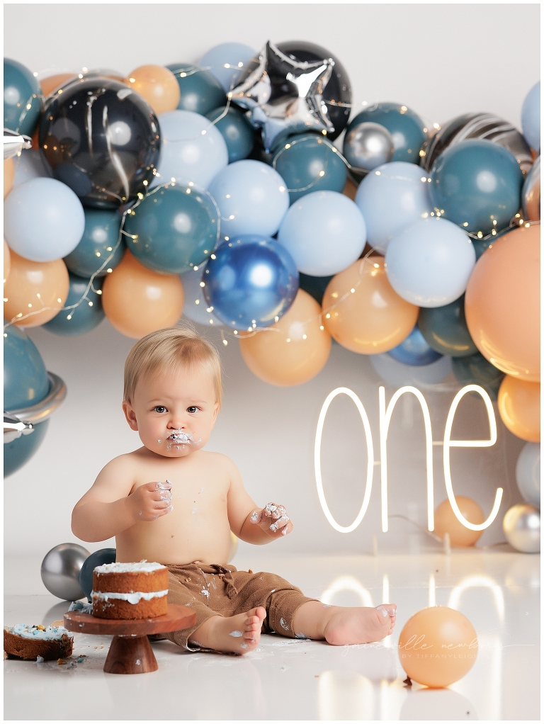 top gun,gainesville,florida,ocala,lake city,first birthday,one year old,cake smash,custom cake smash set,balloon garland,party,almost one,newborn to birthday,growing up,professional photography studio,premier cake smash photographer,celebrate,uf shands,hca north florida,first birthday cake,cake topper,theme,messy,icing,